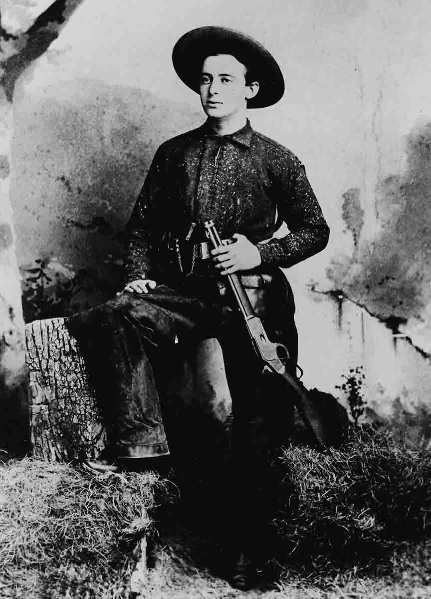 This vintage photo shows a young man with his special order Winchester Model 1873 saddle ring carbine with a barrel measuring less than 20 inches.